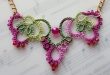 crochet jewelry pink crochet necklace laying on music book CNRXBMH